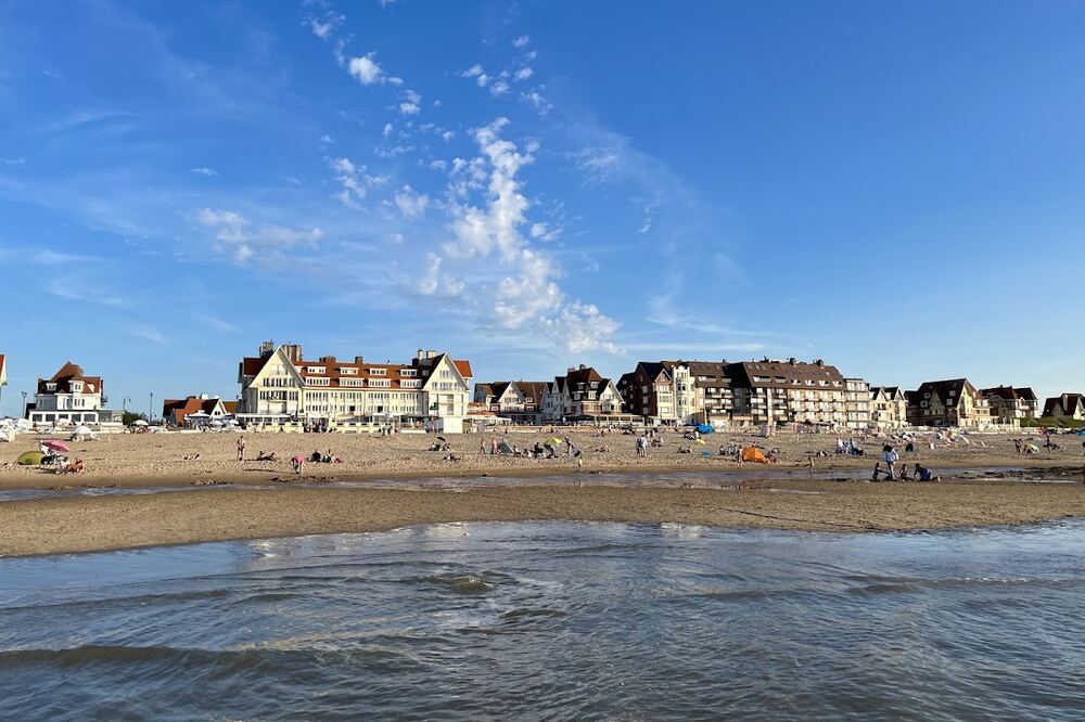 Het strand van De Haan met de belle-époquegevels langs de zeedijk